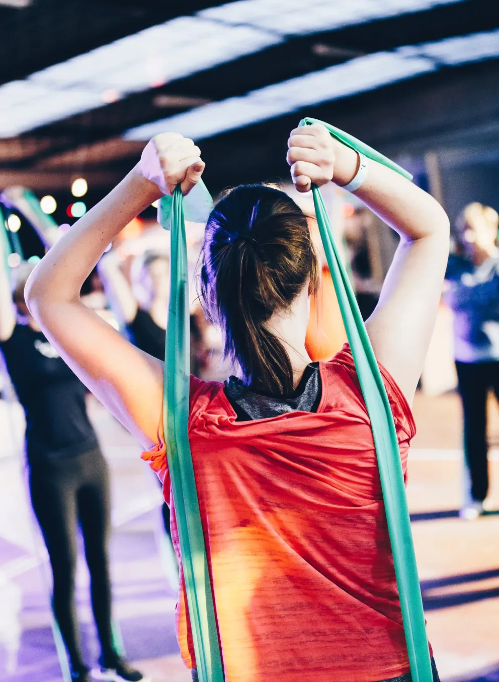 A fitness class uses resistance bands during a workout; participants stretch and strengthen muscles.